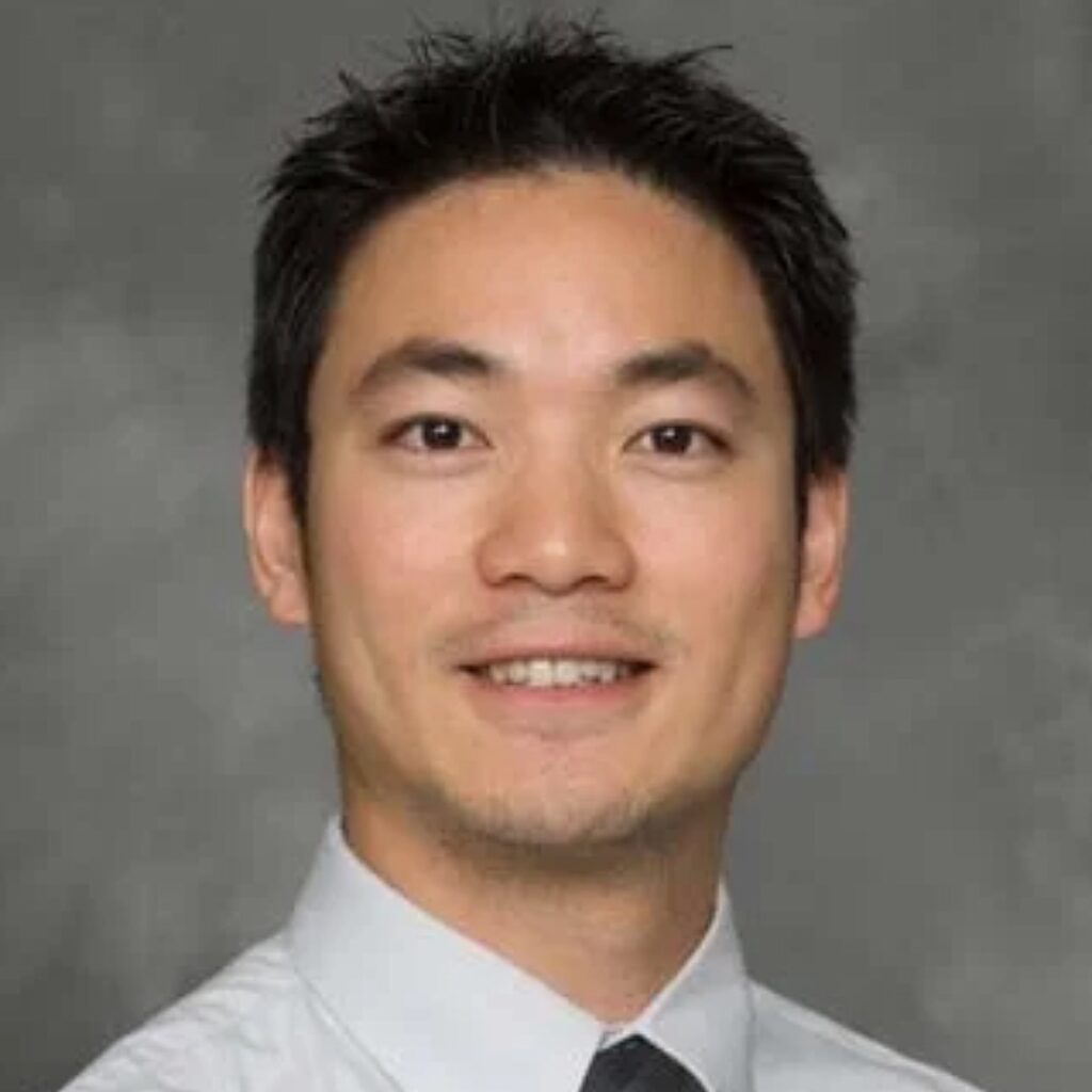 Dr. Ting - male veterinarian wearing a gray button up shirt and a neck tie