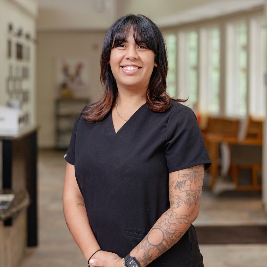 Jasmine-female with dark hair and bangs wearing black scrubs